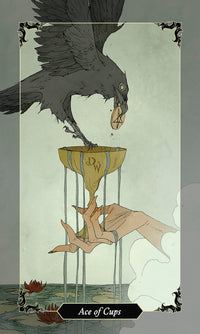 card labeled "ace of cups." image depicts a hand holding an overflowing cup. a crow is standing in the cup holding a pentacle in its beak
