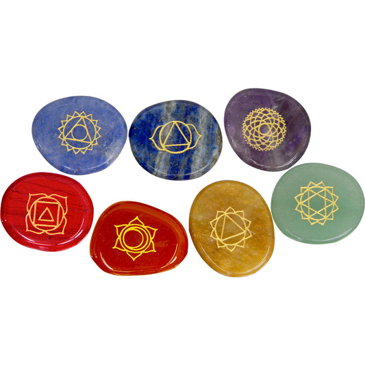 image of seven polished gemstone disks, each carved with a symbol depicting one of the chakras.