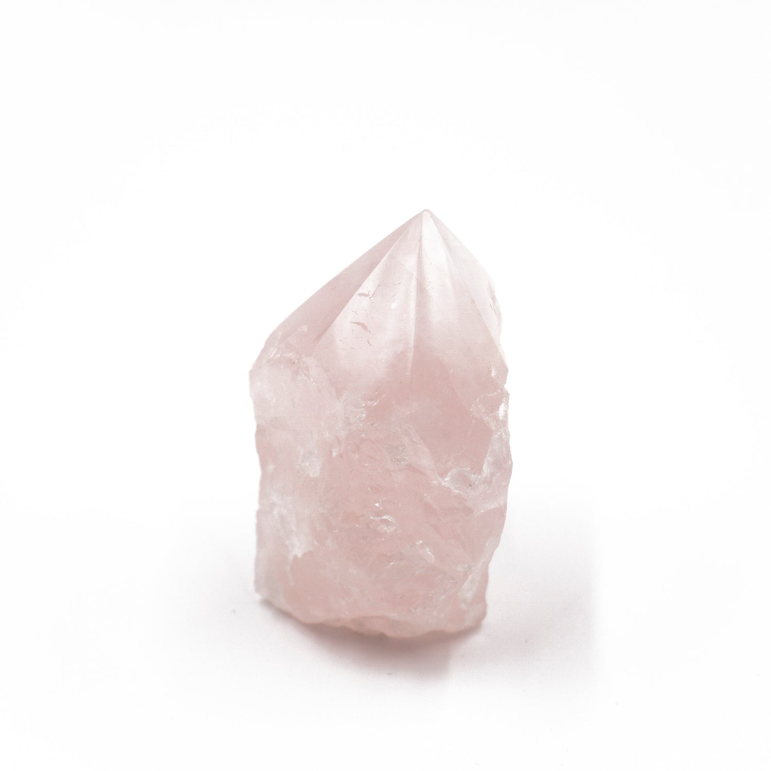 rough cut piece of pink crystal, its top faceted into a point